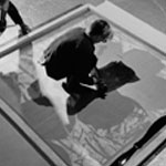 Andy and Gerard Malanga silkscreening the background onto a flower painting, the Factory, New York City, March 1965