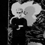 Andy with one of his large flower paintings, the Factory, NYC, 1965